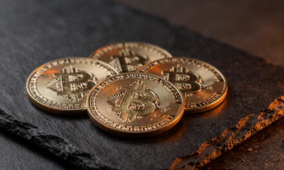 Goldene Bitcoin und Ethereum M&uuml;nzen auf schwarzem Schiefer - Krypto-Zahlungen bei Vox Casino